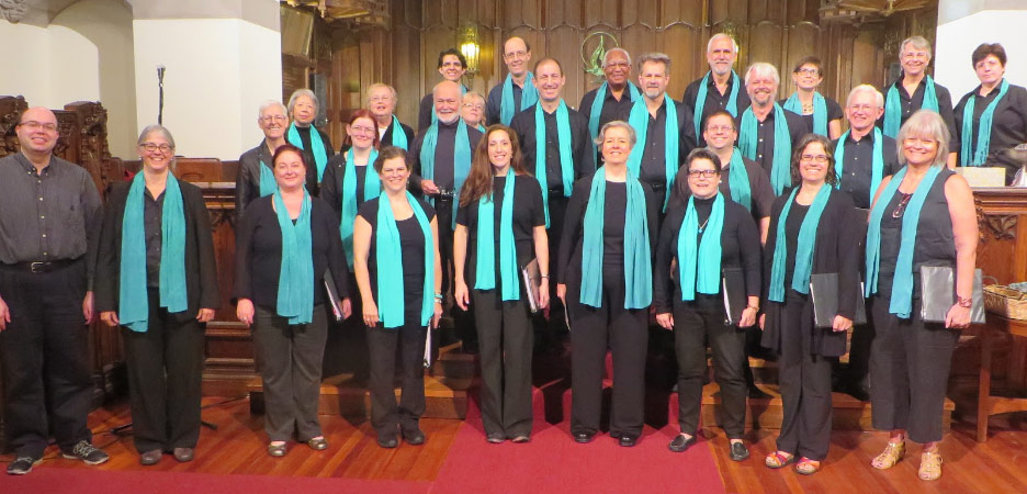 Sanctuary Choir, a group of adults dressed in black and wearing blue sashes stand in a church.