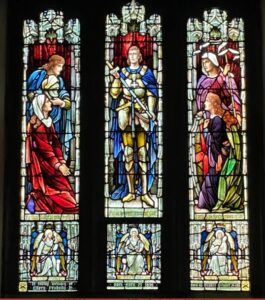 A gorgeous stained glass windows with three large panes and three smaller ones.