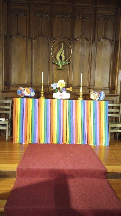 The chancel of the Sanctuary is decorated with rainbow strips of crepe paper streamers and paper flowers.