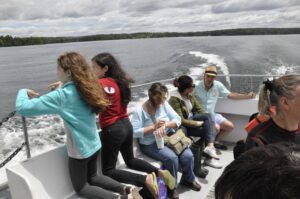 Several adults and children ride a ferry to Sandy Island.