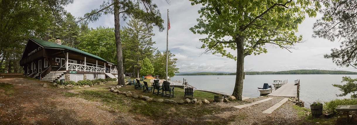 A panoramic view of Sandy Island with a dock and boathouse on a lake.